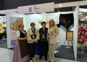 Predstavnici HNV-a na sajmu ispred izložbenog prostora Općine Ernestinovo, preuzeto s Facebook stranice INNATUS - Initiative for Naïve Art and Sustainable Tourism